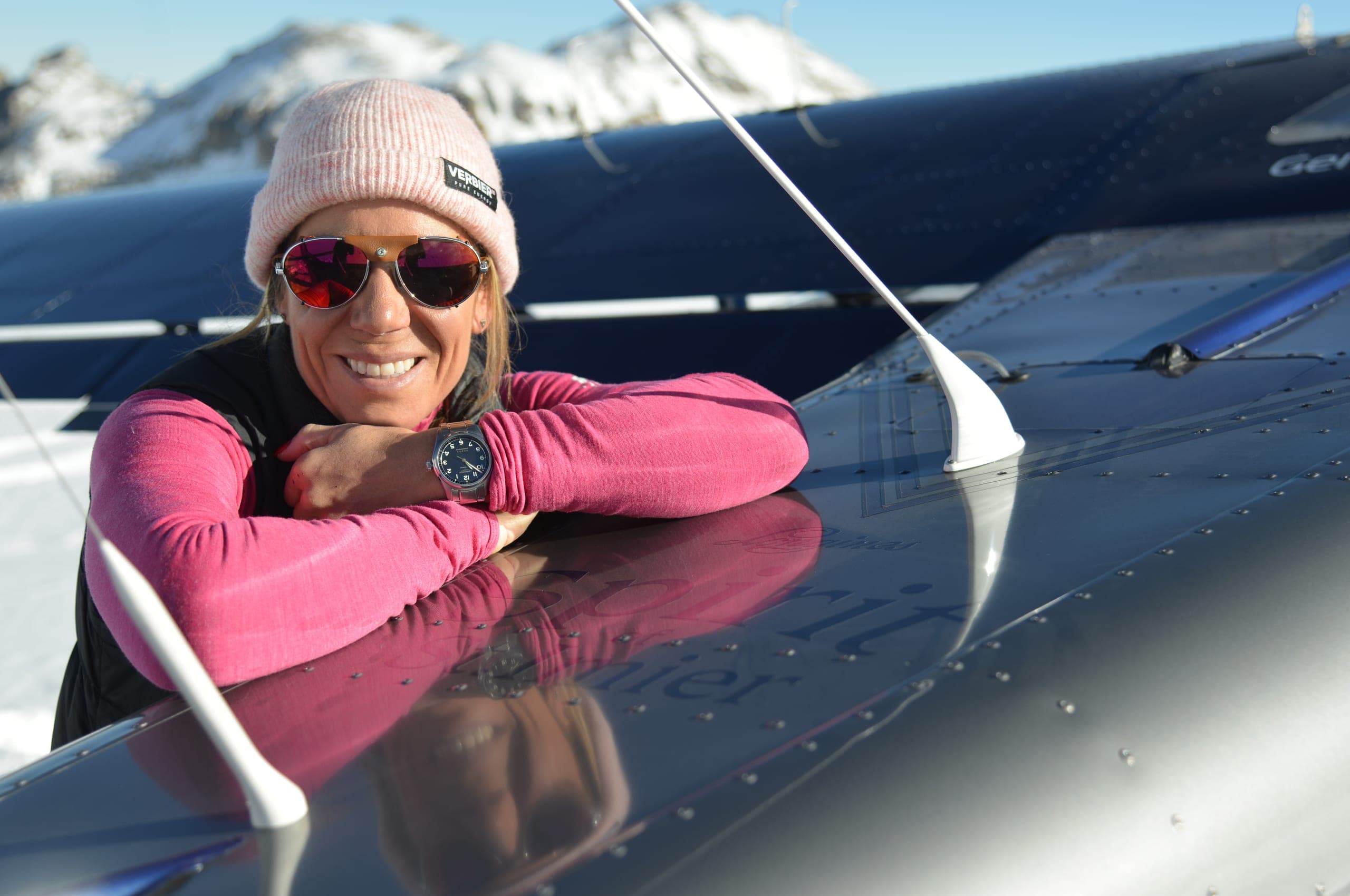 Géraldine Fasnacht devant l’hélice de son avion ultraléger posé sur un glacier, séracs en arrière-plan.